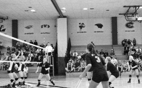 Mackenzie Suda (No. 13), senior setter for the Falcons, gets ready to set the ball.