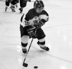 Kait Mason, senior forward, handles the puck in a women’s hockey game.