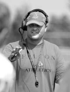 Head football coach Matt Walker talks to players.