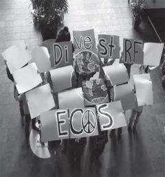 Members of the UW-River Falls ECOS club hold signs on 2015 Global Divestment Day in the University Center.