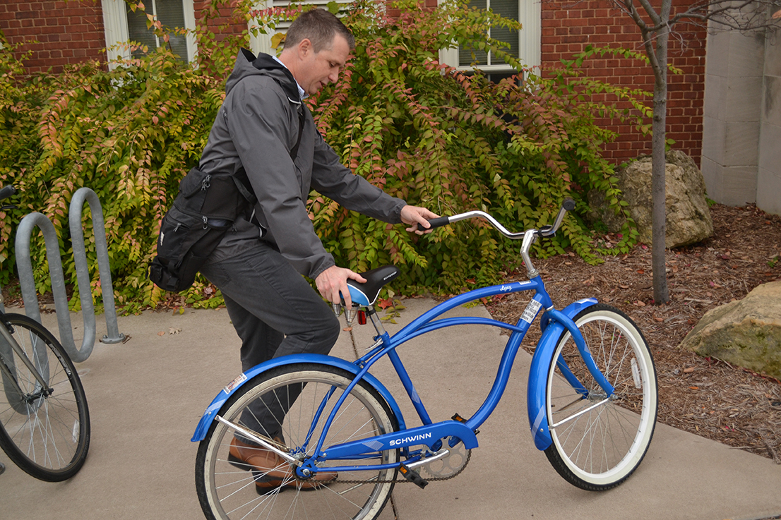Mike Noreen, the conservation and efficiency coordinator for the city of River Falls, gets ready to ride one of the blue bikes outside of North Hall, Oct. 26. Photo by Zach Dwyer/Falcon News Service