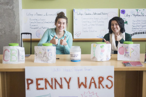 Marissa Koller (left), a junior and Adrianna Erickson, man the Penny Wars table in the University Center, Dec. 6. Photo by Tori Schneider/Student Voice